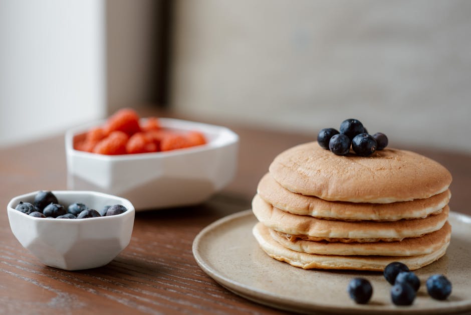 Stack of pancakes with blueberries on a breakfast table